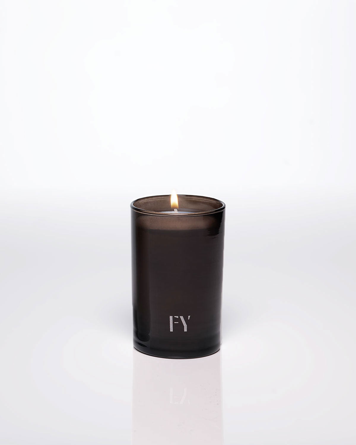 Lit 4oz FREE-YOURSELF EAU candle in dark vessel