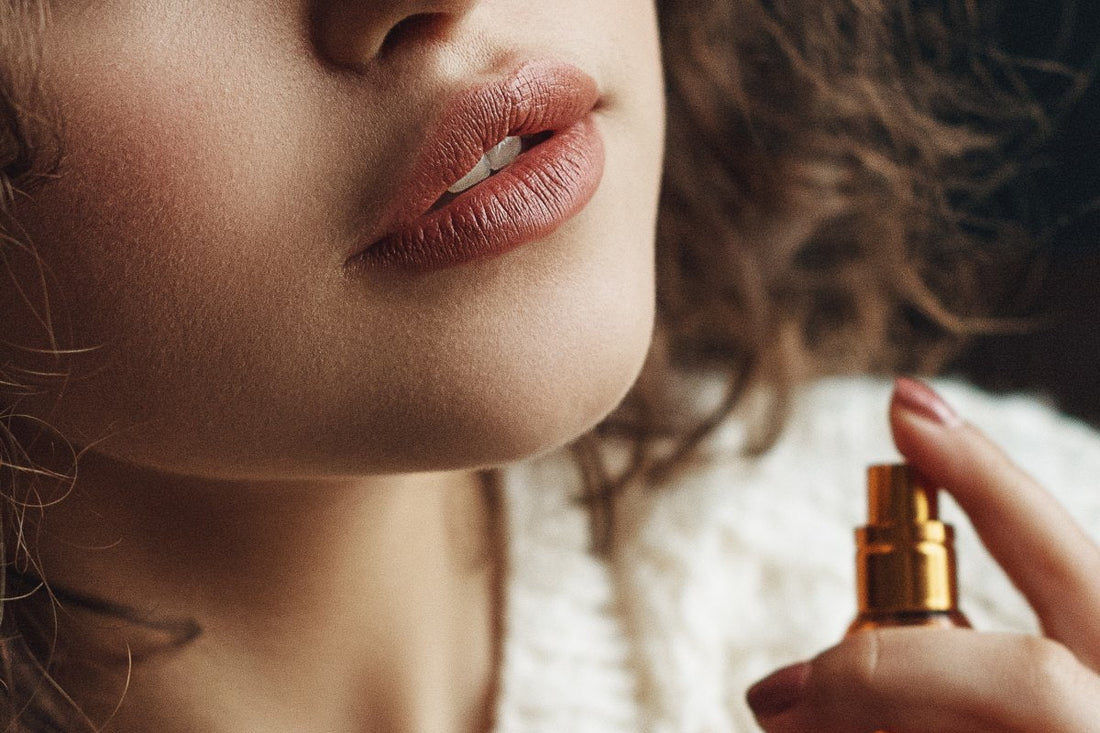 Woman spraying fragrance near her neck, a visual comparison concept for cologne vs perfume