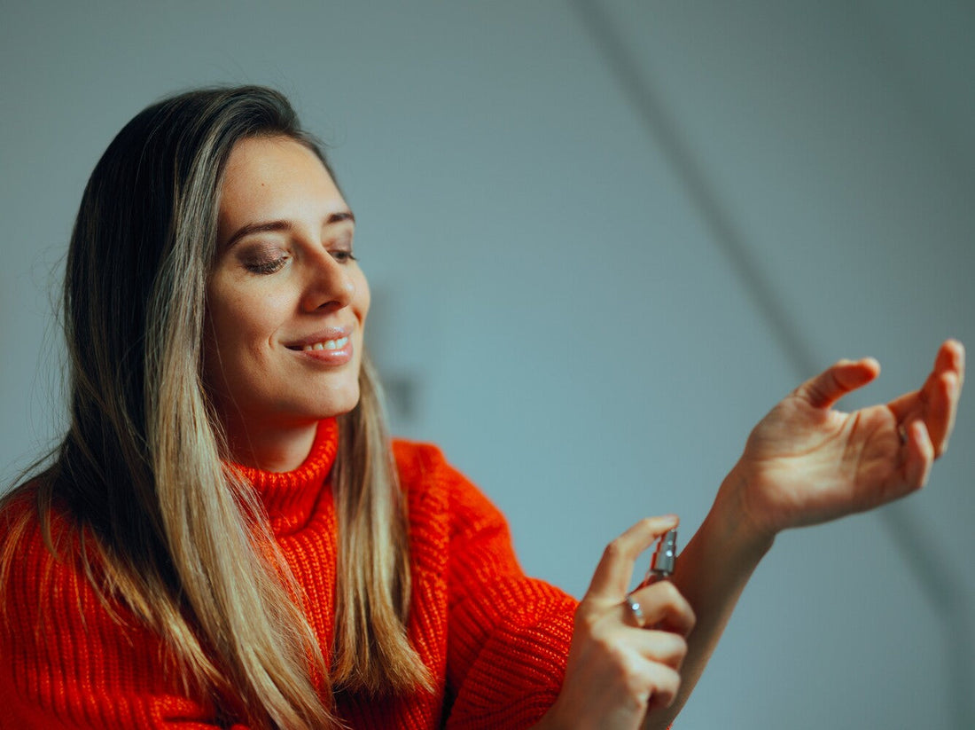 woman applying perfumes to her wrists to find out how long does perfume last