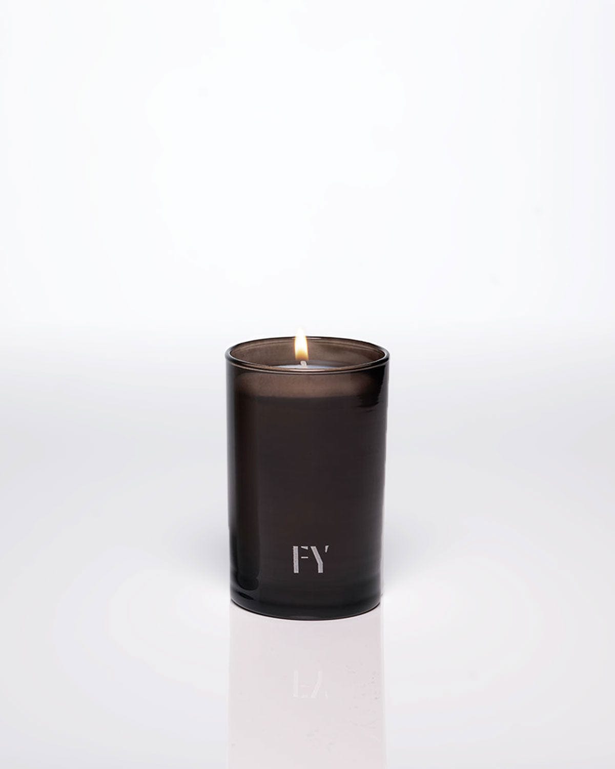 Lit 4oz FREE-YOURSELF EAU candle in dark vessel