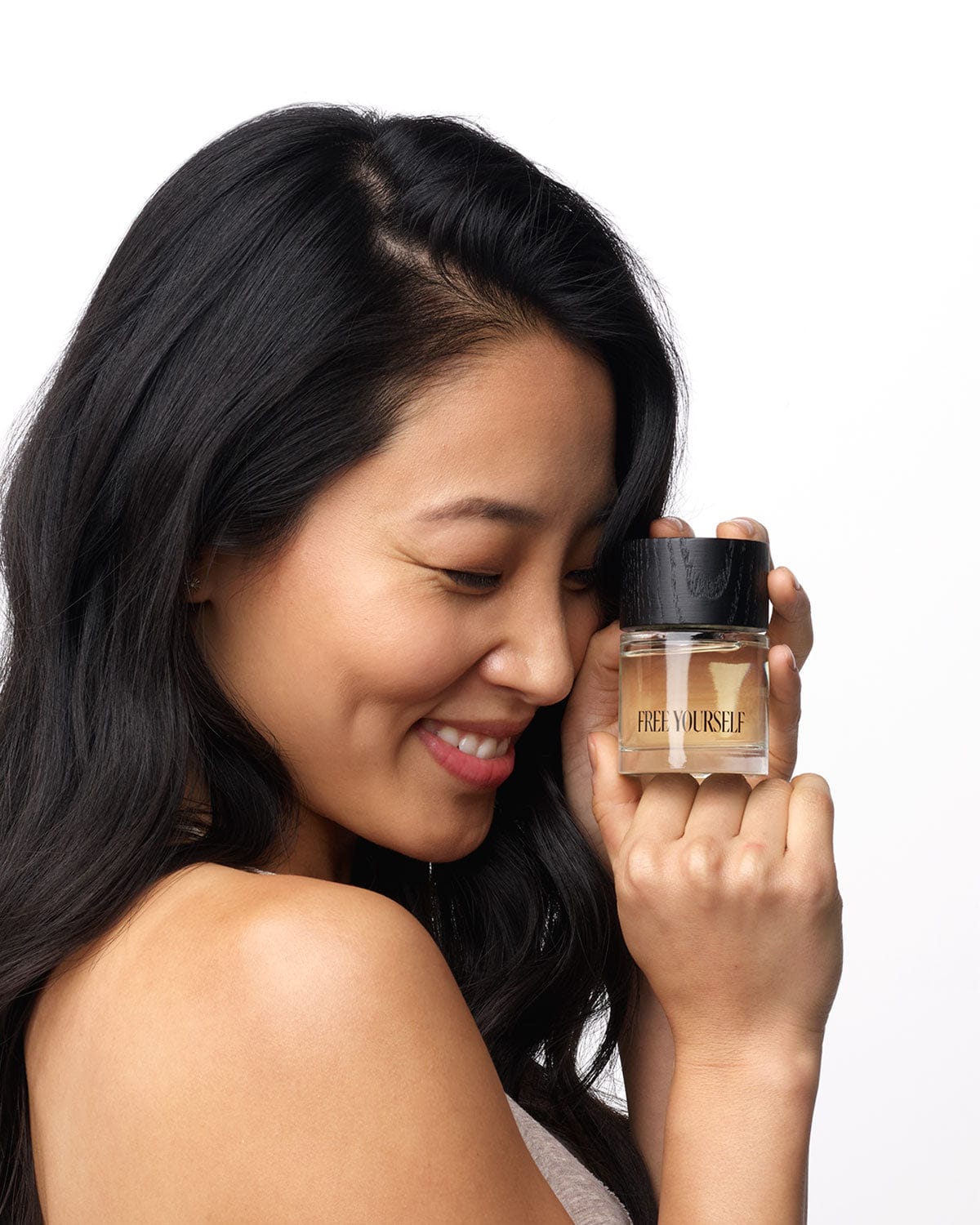 Woman holding FREE YOURSELF perfume 50ml