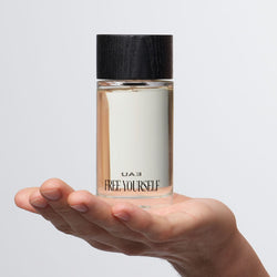 UAU Free Yourself Eau de Parfum 100ml bottle held in hand.