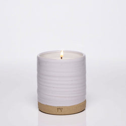 Lit hand-poured candle in ceramic vessel, made in Vermont.
