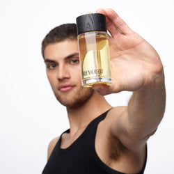 Man holding FREE YOURSELF 100ml EDP fragrance bottle