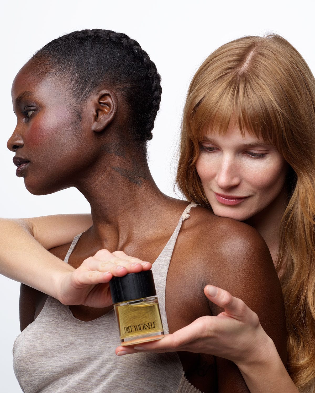 Two women holding Free Yourself 50ml EDP bottle